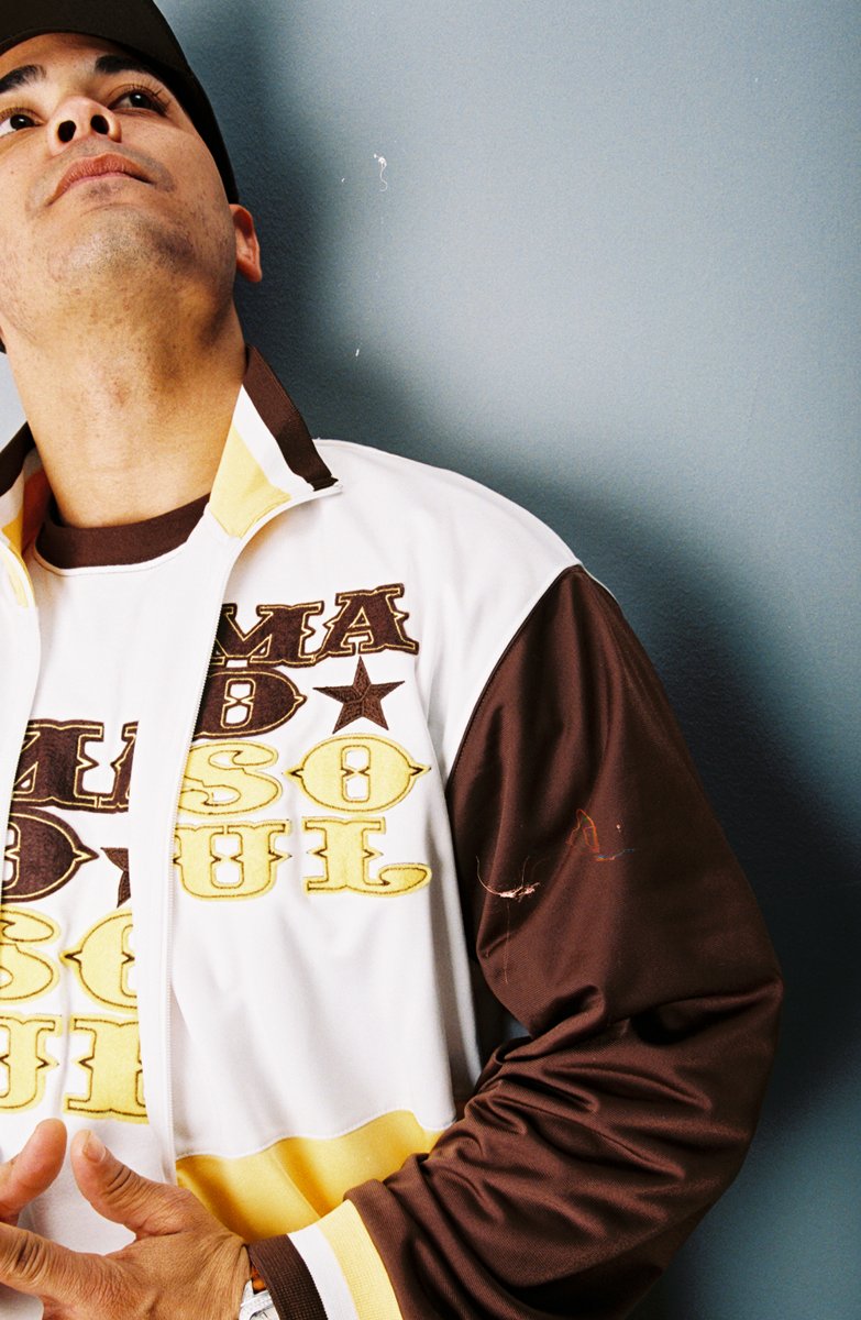 Close crop studio portrait of a model in the brown gold Madsoul track jacket
