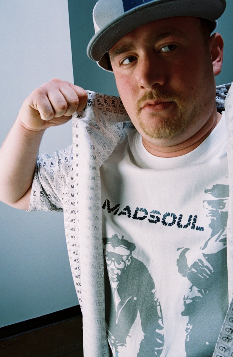 Model holding open a jacket revealing a b-boy graphic tee and element-badge lining pattern